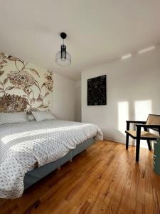 een slaapkamer met een bed en een houten vloer bij Maison de campagne normande in Pitres