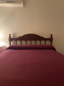 蒂諾加斯塔的住宿－Urqu-Pacha Alojamiento，一间卧室配有一张红色棉被的床
