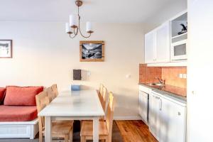 a kitchen and dining room with a table and a couch at Résidence Quartier Falaise - maeva Home - Appartement 2 Pièces 6 Personnes 854 in Avoriaz