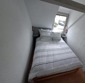a bed in a small room with a window at Bright house with terrace and garden in Camiers
