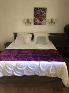 Una gran cama blanca con una manta morada. en Hôtel du Golf de Pont Royal - maeva Home - Appartement 2 pièces 4 personne 874, en Mallemort