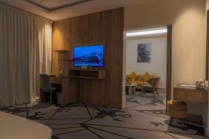 um quarto de hotel com uma televisão na parede em فندق ساس - SAS Hotel em Hafr Al-Batin