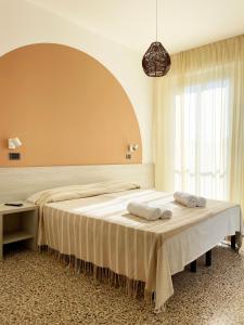a bedroom with a large bed with towels on it at Hotel Reale in Rimini