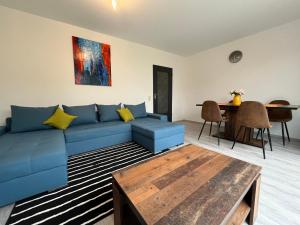 uma sala de estar com um sofá azul e uma mesa em Serene Meadows Apartment em Solingen