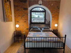 a bedroom with a bed in a brick wall at Loft pod Starym Kasztanem in Krynica Zdrój