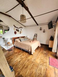 1 dormitorio con 1 cama y suelo de madera en CABAÑAS EN ZONA 16 en Guatemala