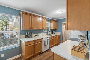 a kitchen with wooden cabinets and a counter top at The Hickory House with Firepit- Boat Ramp Access to Cedar Creek Lake in Tool