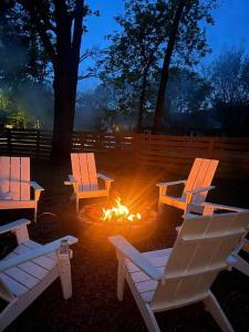 three white chairs sitting around a fire in a yard at The Hickory House with Firepit- Boat Ramp Access to Cedar Creek Lake in Tool