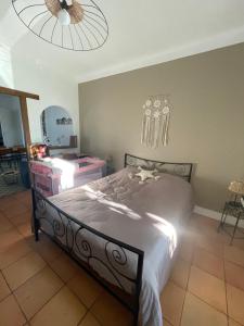 a bedroom with a bed and a ceiling fan at Du côté de chez nous in Cuxac-dʼAude