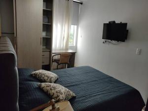 a bedroom with a bed and a tv on the wall at Hermoso Apartamento en la mejor zona de la ciudad in Armenia