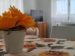 un jarrón lleno de flores naranjas sentado en una mesa en Casa Vacanze La Pineta del Mare, en Torre Ovo