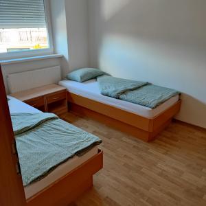 a bedroom with two beds and a window at SOSTANJ VELENJE RAVNE SOBE ROOMS Vrtacnik d o o in Šoštanj
