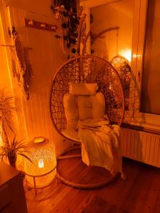 a room with a rattan chair with pillows at Maison ZEN avec Sauna in Ronchin