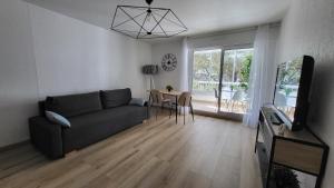 ein Wohnzimmer mit einem Sofa und einem Tisch in der Unterkunft Appartement de 50 m2 cosy et moderne à 100 m de la plage in Saint-Mandrier-sur-Mer