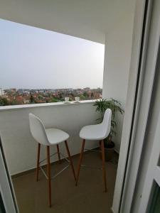 two white chairs sitting on top of a balcony at Apartman Bross in Ruma