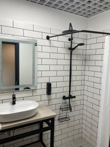a white bathroom with a sink and a mirror at Apartment Loftas13-6 in Kretinga
