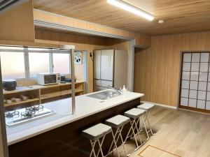 una cucina con lavandino e bancone con sgabelli di Izumo no Oyado Naka Araki - Vacation STAY 82773v a Izumo