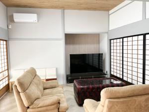 a living room with two chairs and a flat screen tv at Izumo no Oyado Naka Araki - Vacation STAY 82773v in Izumo