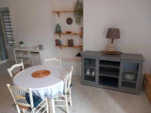 a dining room with a table and chairs and a cabinet at Balade sur le port in Dinan