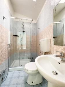 a bathroom with a toilet and a shower and a sink at Hotel Reale in Rimini