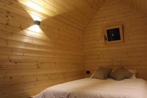 um quarto com uma cama num chalé de madeira em Hiška-Glamping em Ajdovščina