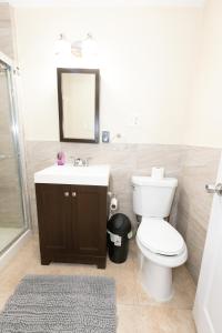 a bathroom with a toilet and a sink and a mirror at Bright 2-Bed Haven Close to NYC in Jersey City