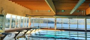 a large swimming pool with a view of the water at Apartamento-Suite Playa en San Antón in Porto de Espasante