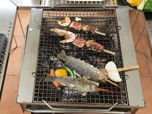 Riverside Glamping Kamiseno - Vacation STAY 92770v في هيروشيما: شواية عليها سمك وخضار