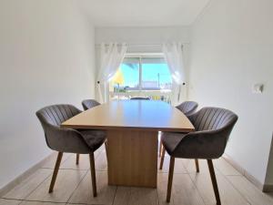 Una mesa y sillas en una habitación con ventana. en Apartment Oasis Park AL, en Portimão