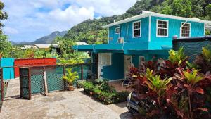 a blue house with a fence in front of it at Amazon Villas in Soufrière