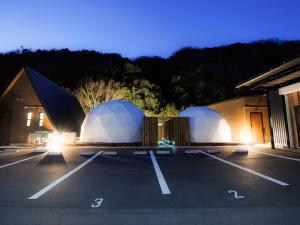 two domes in a parking lot next to a building at Riverside Glamping Kamiseno - Vacation STAY 92757v in Hiroshima