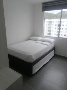a bed in a room with a large window at Aqualina Orange Girardot, décimo piso in Girardot