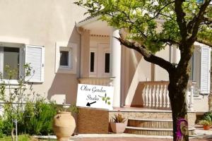 a house with a sign on the front of it at Olive Garden Studio in Mandrotopos