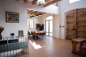 een grote kamer met een tafel en houten deuren bij Radiant 5 BR family home with jacuzzi + roof deck in Palau de Santa Eulalia