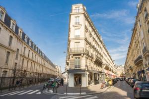 un grand bâtiment blanc au coin d'une rue dans l'établissement Appartement Tour Eiffel & Trocadéro, à Paris