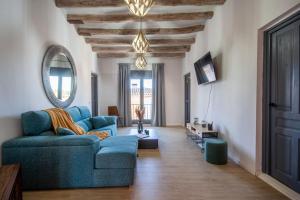 a living room with a blue couch and a mirror at Radiant 5 BR family home with jacuzzi + roof deck in Palau de Santa Eulalia