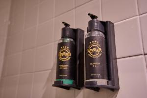 two black shampoo bottles sitting on a bathroom wall at South American Copacabana Hotel in Rio de Janeiro