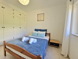 een slaapkamer met een bed met 2 kussens erop bij Apartment Oasis Park AL in Portimão