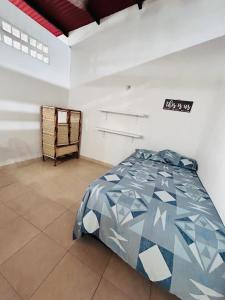 um quarto com uma cama num quarto branco em CASA HONDANA em Honda
