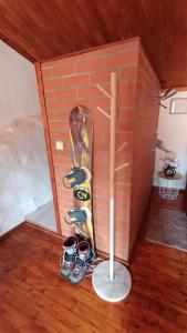 uno skateboard appoggiato a un muro di mattoni in una stanza di Orion Guesthouse Telhado a Fundão