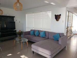 a living room with a purple couch and a glass table at Bujama vista al mar in Asia