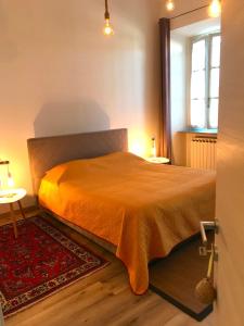 a bedroom with a bed with an orange bedspread at ANTICA FILANDA Lattes in Cuneo