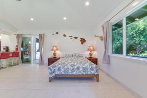 a bedroom with a bed and a large window at Bright Haiku Studio Patio and Rainforest View in Haiku