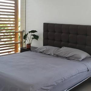 - un grand lit avec une grande tête de lit dans une chambre dans l'établissement Bujama vista al mar, à Asia