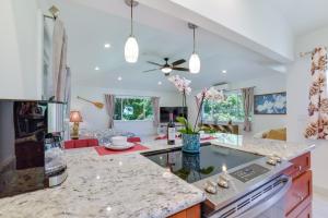a kitchen with white walls and marble counter tops at Bright Haiku Studio Patio and Rainforest View in Haiku