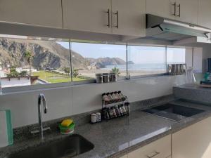 a kitchen with a sink and a view of the beach at Bujama vista al mar in Asia