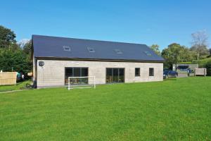 a white building with a black roof on a grass field at stylish and modern Spacious 2 bedroom apartment in Clodock