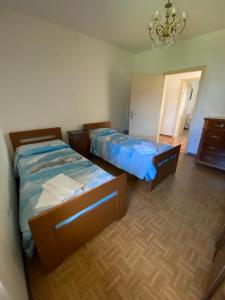 1 dormitorio con 2 camas y lámpara de araña en Residenza Soladiva, en Cles