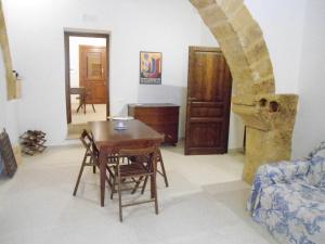 - un salon avec une table et des chaises en bois dans l'établissement Residence Marsala Antica, à Marsala