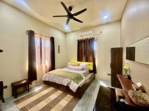Schlafzimmer mit einem Bett und einem Deckenventilator in der Unterkunft Villa Bani Hashim in Pantai Cenang
